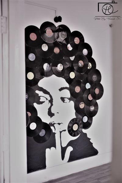 A lady with records on her head in the shape of a hairstyle. "Wall Art" by artist Iqra Saeed Khattak. marriagecat.com- art in Pakistan