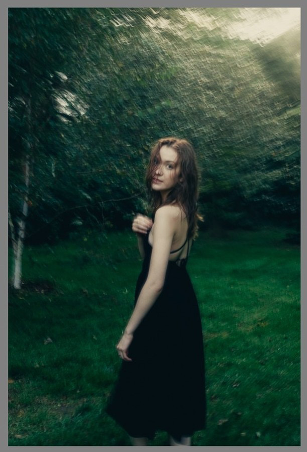Color photo of Catrina Conway with black dress, dark green grass, and shady trees. Marriage Cat Magazine - festive poetry.